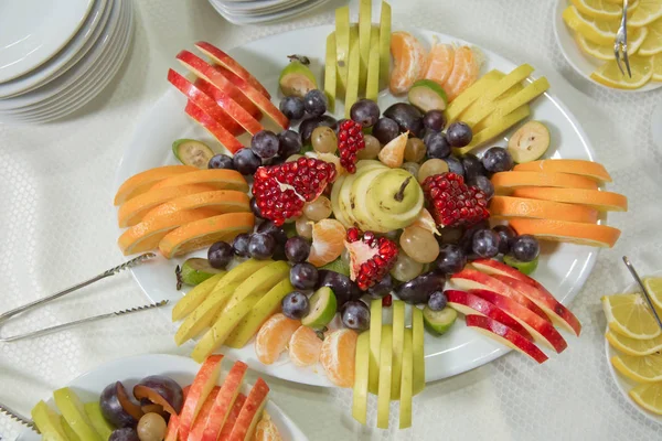 Mandarin, szőlő, gránátalma, alma, narancs, ACCA sellowiana. szeletelt gyümölcsök a tányéron belül. — Stock Fotó