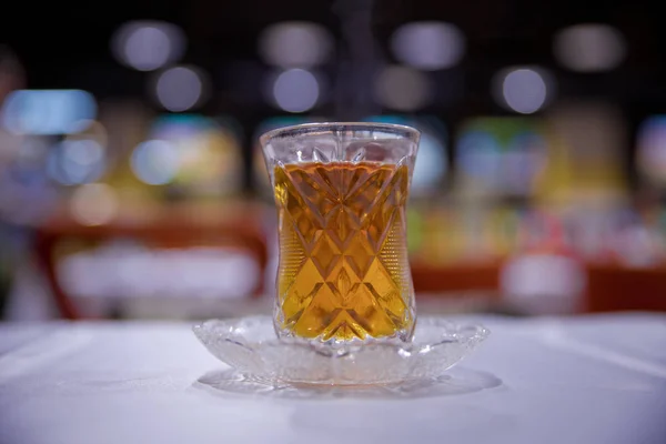 Thé en verre traditionnel armudu azerbaïdjanais en forme de poire. Thé noir Azerbaïdjan avec table blanche vintage. Thé turc noir en verre en forme de poire, thé aromatique azerbaïdjanais traditionnel en tasse armudu . — Photo