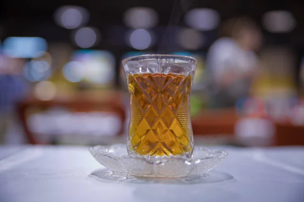 Thé en verre traditionnel armudu azerbaïdjanais en forme de poire. Thé noir Azerbaïdjan avec table blanche vintage. Thé turc noir en verre en forme de poire, thé aromatique azerbaïdjanais traditionnel en tasse armudu . — Photo