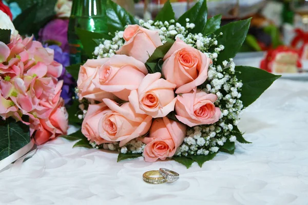 Gouden trouwringen op de roze boeket van bloemen. Stijlvolle roze verlovingsring bloem ringen voor de bruiloft boeket . — Stockfoto