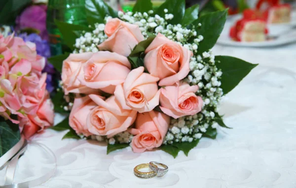 Gouden trouwringen op de roze boeket van bloemen. Stijlvolle roze verlovingsring bloem ringen voor de bruiloft boeket . — Stockfoto