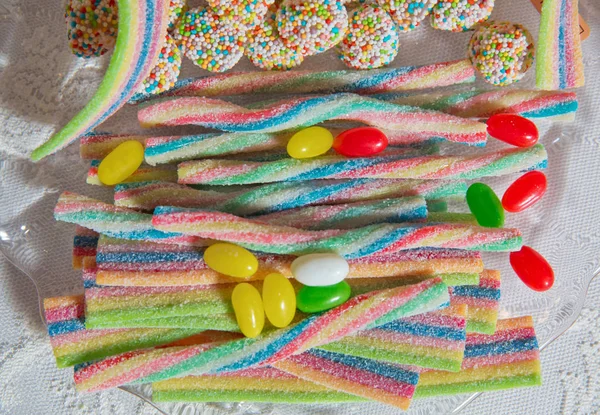 Kolorowe gummy cukierki wzór na białym tle. . Unicorn Rainbow cukierki paski tło bliska. Posypki cukrowe. okrągłe kolorowe cukierki. Posypki cukrowe. Kwaśne tęczowe taśmy cukiernicze. — Zdjęcie stockowe