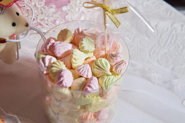 Süßigkeiten in einem Kunststoffglas rosa und gelb. bunte Marshmallow-Bonbons im Plastikbehälter auf weißem Hintergrund. — Stockfoto