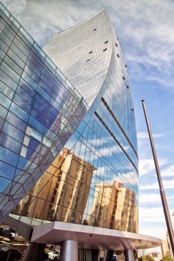 Bulut ayna öğlen mavi gökyüzü arka plan olarak, günlük çalışma için büyük ve taze bir atmosfer ile binanın üzerinde yansıması