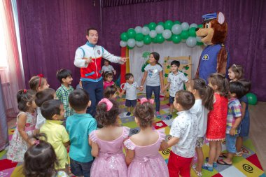 Anaokulunda iki yıl doğum günü. Animatörlerle çocukların doğum günü. Mutlu bir grup çocuk doğum günü kutlamasında bir animatörle pati devriyesi tarzında giyinmişler. .