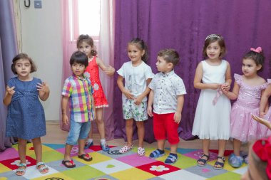 Anaokulunda iki yıl doğum günü. Animatörlerle çocukların doğum günü. Mutlu bir grup çocuk doğum günü kutlamasında bir animatörle pati devriyesi tarzında giyinmişler. .