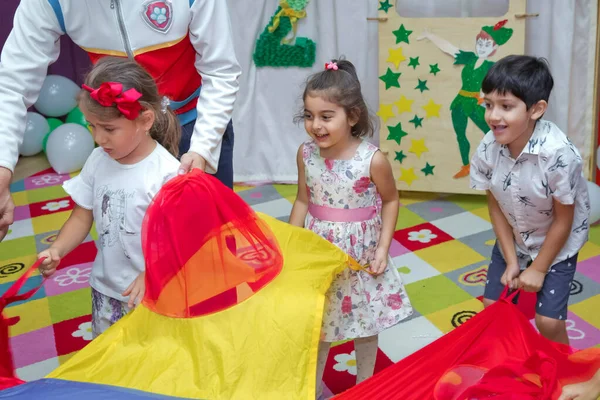 Cumpleaños dos años en el jardín de infantes. Cumpleaños de niños con animadores. Feliz grupo de niños en una celebración de cumpleaños vestidos con el estilo de patrulla de patas con un animador  . —  Fotos de Stock