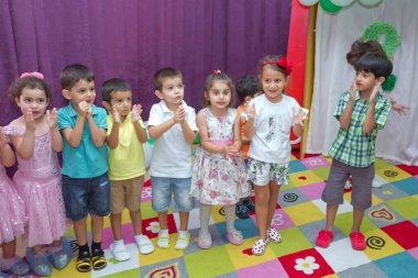 Anaokulunda iki yıl doğum günü. Animatörlerle çocukların doğum günü. Mutlu bir grup çocuk doğum günü kutlamasında bir animatörle pati devriyesi tarzında giyinmişler. .