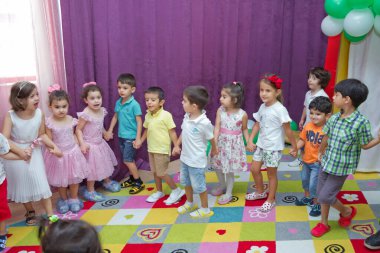 Anaokulunda iki yıl doğum günü. Animatörlerle çocukların doğum günü. Mutlu bir grup çocuk doğum günü kutlamasında bir animatörle pati devriyesi tarzında giyinmişler. .