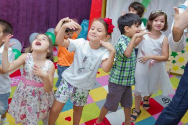 Anaokulunda iki yıl doğum günü. Animatörlerle çocukların doğum günü. Mutlu bir grup çocuk doğum günü kutlamasında bir animatörle pati devriyesi tarzında giyinmişler. .