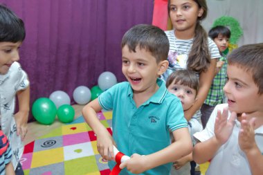 Anaokulunda iki yıl doğum günü. Animatörlerle çocukların doğum günü. Mutlu bir grup çocuk doğum günü kutlamasında bir animatörle pati devriyesi tarzında giyinmişler. .
