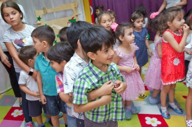 Anaokulunda iki yıl doğum günü. Animatörlerle çocukların doğum günü. Mutlu bir grup çocuk doğum günü kutlamasında bir animatörle pati devriyesi tarzında giyinmişler. .