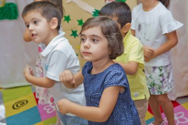 Anaokulunda iki yıl doğum günü. Animatörlerle çocukların doğum günü. Mutlu bir grup çocuk doğum günü kutlamasında bir animatörle pati devriyesi tarzında giyinmişler. .