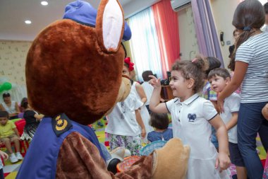 Anaokulunda iki yıl doğum günü. Animatörlerle çocukların doğum günü. Mutlu bir grup çocuk doğum günü kutlamasında bir animatörle pati devriyesi tarzında giyinmişler. .