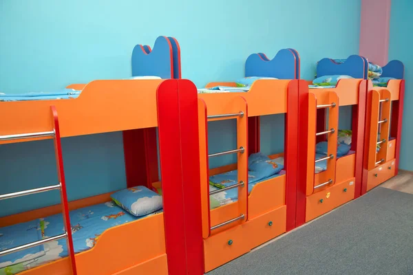 V ložnici je spousta postelí. Prázdný pokoj. Postele v ložnici pro děti. Soukromá školka nebo dětská ložnice. Interiér ložnice ve školce se dvěma patrovými lůžky — Stock fotografie