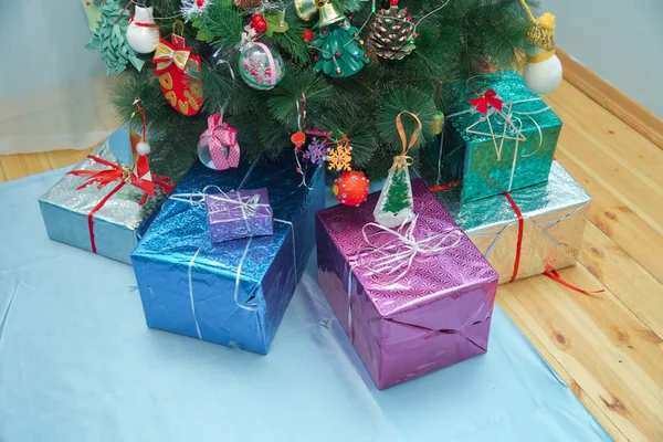 Presentes sob a árvore de Natal. Presentes de Natal embalados com papel colorido e fitas sob árvore decorada. Árvore de Natal e muitos presentes  . — Fotografia de Stock