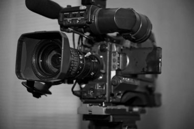 Profesyonel dijital kamera. 4K video kameralar için aksesuarlar. Bir konser salonundaki TV kamerası. Video kamera lensleri - TV stüdyosunda kayıt gösterimi - kamera açıklığına odaklan. Beyaz-siyah renk