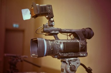 Profesyonel dijital kamera. 4K video kameralar için aksesuarlar. Bir konser salonundaki TV kamerası. Video kamera lensleri - TV stüdyosunda kayıt gösterimi - kamera açıklığına odaklan. Sepya rengi