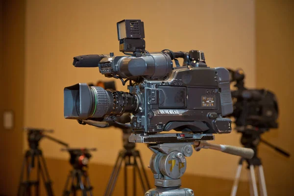 Câmera de vídeo profissional definida em um tripé com excelente caminho de recorte. Câmera de vídeo de produção profissional. câmera de vídeo na sala de conferências de negócios participantes de gravação — Fotografia de Stock