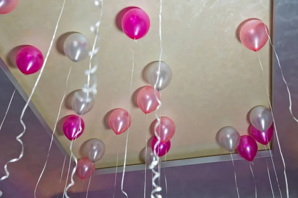 Heliumballons. Bunte Luftballons schweben an der weißen Decke im Partyraum. Hochzeit oder Kindergeburtstag Dekoration Innenraum. — Stockfoto