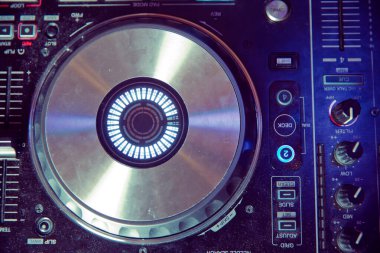 Partide müzik çalmak için kulüp disk jokeyi sahne ekipmanı. Gece kulübü için dijital dönüş tablosu. Ses karıştırıcı paneli ve jog tekerleği olan profesyonel konser DJ pikabı cihazı..