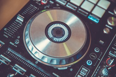 Partide müzik çalmak için kulüp disk jokeyi sahne ekipmanı. Gece kulübü için dijital dönüş tablosu. Ses karıştırıcı paneli ve jog tekerleği olan profesyonel konser DJ pikabı cihazı..