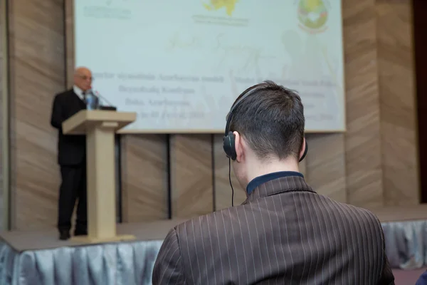 Hombre con auriculares en la conferencia .head teléfono para la traducción en línea. Personas irreconocibles que usan auriculares para traducir durante el evento —  Fotos de Stock