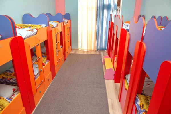 Sok ágy van a hálószobában. Üres szoba. Ágyak a hálószobában gyerekeknek. Saját óvoda vagy óvoda hálószoba. Egy óvodai hálószoba belseje kétszintes ágyakkal — Stock Fotó