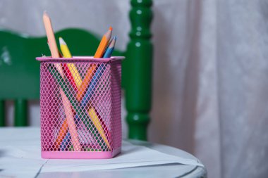 Beyaz arka planda kalem kutusunda renkli kalemler. Beyaz arka planda pembe çantadaki renkli kalemler izole edilmiş. Renkli kalemlerin yaratıcı konsept çekimi. Kalemler ve kalemler için kutu .