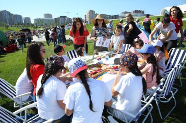 Bakü, Azerbaycan - Haziran 12019: Çocuk festivali. Heydar Aliyev Merkezi 'nin parkında. Çocuklar resim çiziyor.