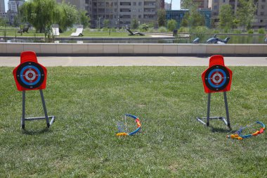 Çocuk festivali. Okçuluk Oku Vakumlama Oku Hedef Tahtası Açık Bahçe Oyun Oyuncağı. Çocuklar için Oyuncak Yay ve Ok - Okçuluk Oku, Hedef ve Titrek yeşil arkaplan .