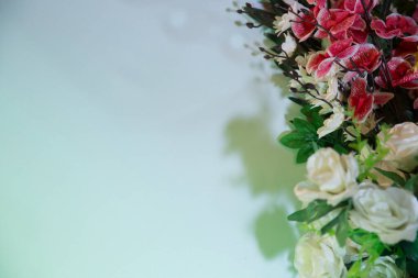 Büyük Beyaz Güller 'in çelengi. Güller Garland Yapay İpek Çiçekleri. Beyaz güllerle kusursuz bir sınır. Beyaz arka planda izole edilmiş. Yazmak için boş yer. Kırmızı orkideler çiçek .