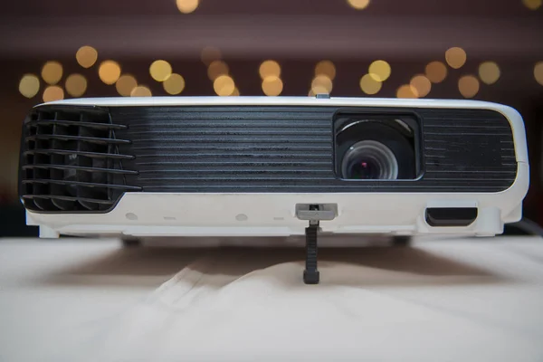Close up projector in conference room . LCD Projector technology video presentation and home Entertainment object . mini led projector on wood table in a room projector home theater idea and concept