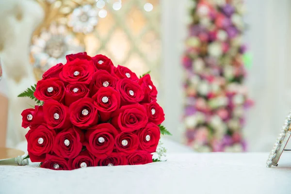 红玫瑰上的结婚戒指 一套红玫瑰婚戒拍下了特写 新娘和新郎在红色的婚礼花束上戒指 结婚用的一束玫瑰 — 图库照片