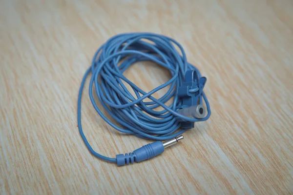 Blue Microphone and headphone splitter cable . Audio Mini Jack Cable for microphone isolated on wooden background .