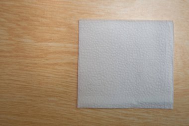 White Square Bar Peçetesi ahşap arka planda izole edilmiş. Tahta zemin üzerinde boş kağıt peçete ve fotokopi alanı. Ahşap arka planda beyaz peçete, beyaz peçetelerin birçok görüntüsü, boş model dosyaları .