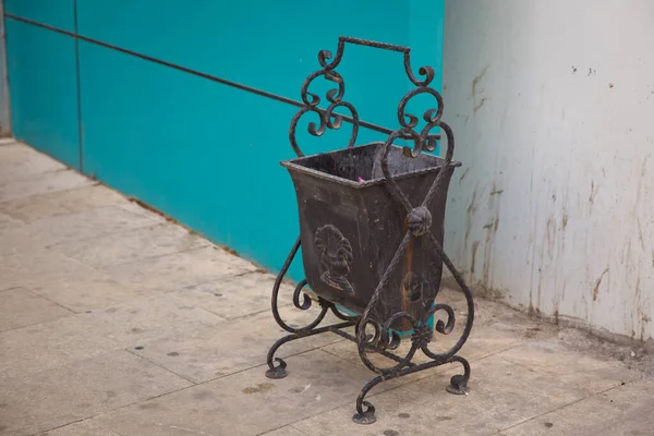 Garbage can on top of asphalt . Black trash can in the yard of the building . Black copper metal garbage bin in building with blurred . — Stock Photo, Image