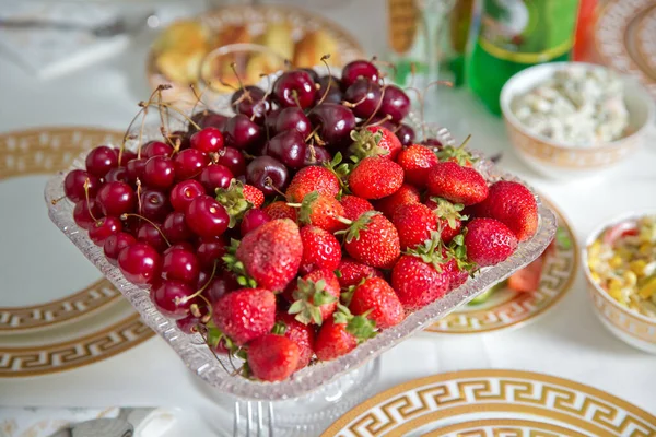 Fresh summer fruits: cherries, organic strawberries crystal bowl . Strawberries and cherries in a crystal bowl.