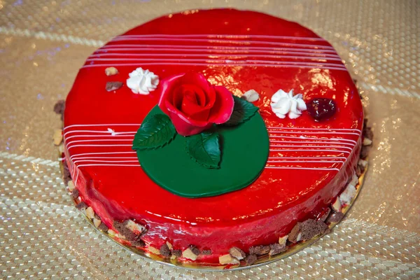 Red round cake. Red flowers on the cake. Red rose on the cake .