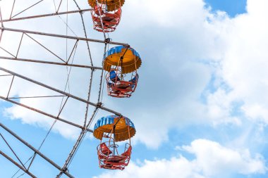 Bulutlu mavi gökyüzü arka plan üzerinde renkli dönme dolap.