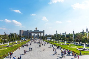 Moskova, Rusya - 22 Eylül 2018: Panoramik VDKNh ana giriş ve Moskova'da güneşli havada yürüyen insanların Arch.