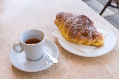 Kahve ve kruvasan koyu çikolata ile. Üstten görünüm ve yakın çekim.