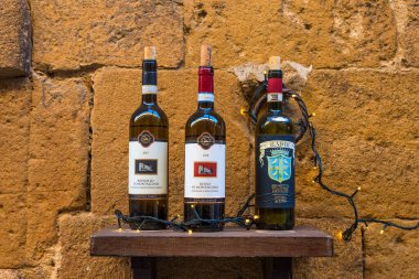 Pienza, İtalya - 4 Ocak 2019: Pienza, Tuscany, İtalya 'daki şarap dükkanı veya restoranın dekorasyonu için çeşitli Toskana şarabı şişeleri