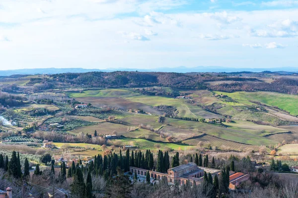 Γραφική θέα χειμερινό τοπίο της Τοσκάνης με πέτρινα σπίτια, πολύχρωμους λόφους, χωράφια και αμπελώνες στην Ιταλία. — Φωτογραφία Αρχείου