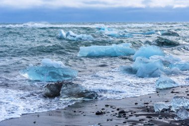 Jokulsarlon gölü yakınlarında buzdağı parçaları bulunan siyah kumsal manzarası inanılmaz. Kış zamanı İzlanda..