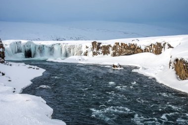 İzlanda 'daki Godafoss şelalesinin manzarası. İzlanda 'da donmuş şelaleli resimli kış manzarası.