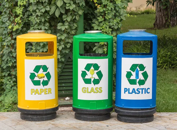 Three multicolored recycle bins for waste with icons for the convenience of sorting junk waste in the garden