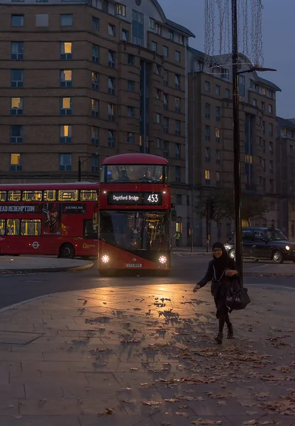 ЛОНДОН, ОБЪЕДИНЕННЫЙ КИНГДОМ - 24 НОЯБРЯ 2018 года: Традиционный лондонский красный автобус проходит ночной перекрёсток — стоковое фото