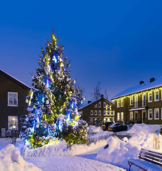 Evleri yakınında sokakta parlak ışıklar ile Noel ağacı Noel ve yılbaşı için dekore edilmiş