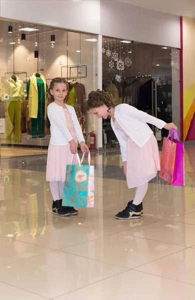 Deux jeunes filles avec des sacs à provisions discuter de l'achat au centre commercial — Photo